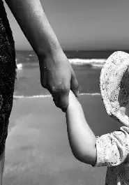 Maman et enfant se tenant la main sur la plage