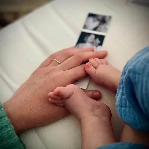 Une main de maman et les pieds de l'enfant